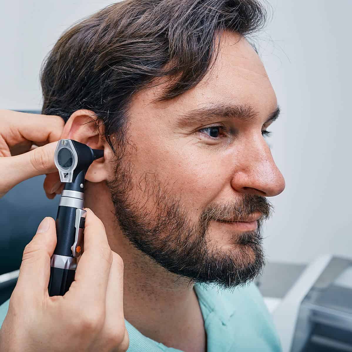 Man with otoscope in his ear