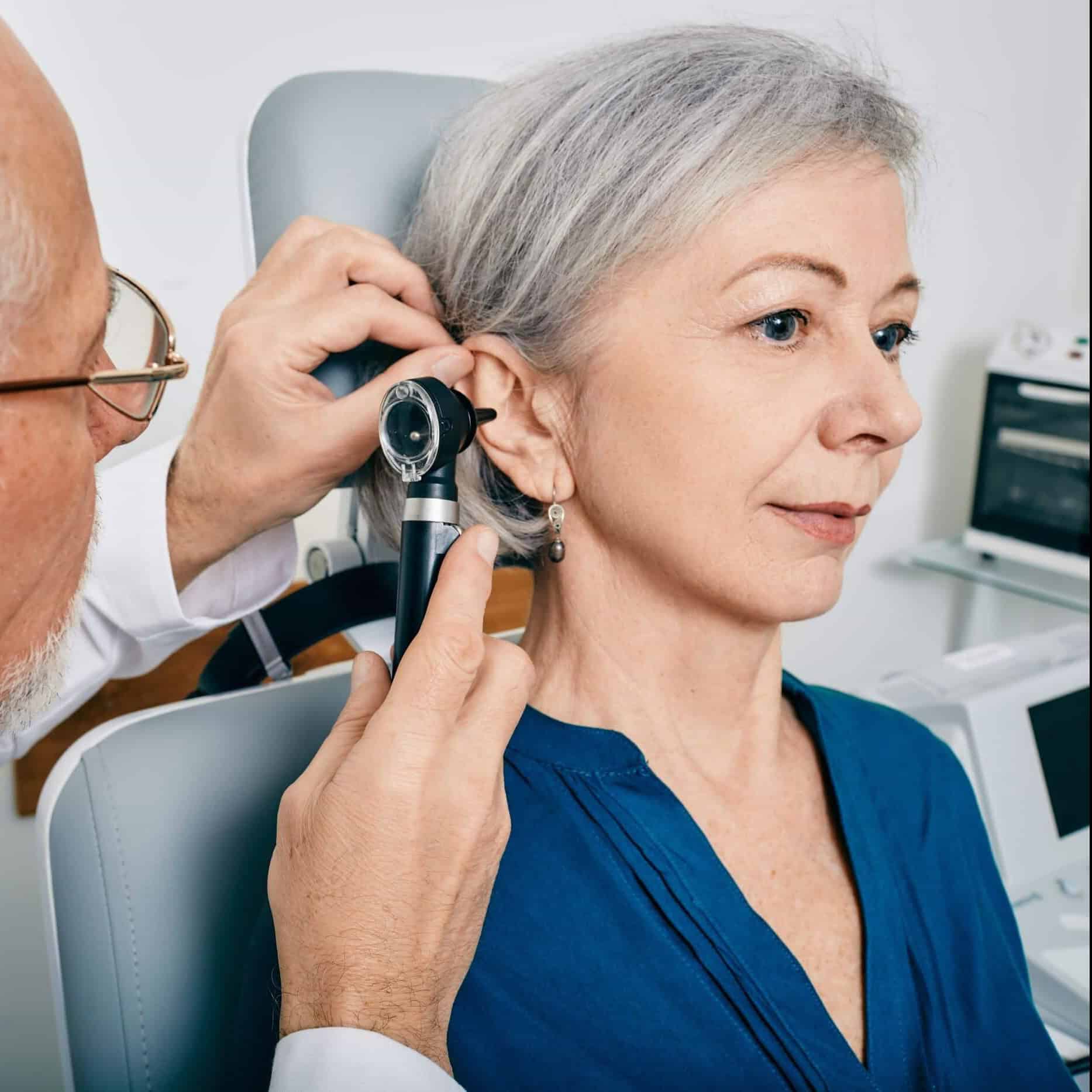 Audiologist giving patient hearing exam