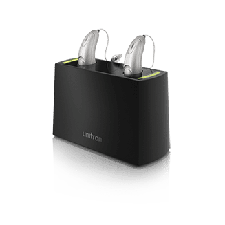 Pair of Unitron hearing aids in their charger